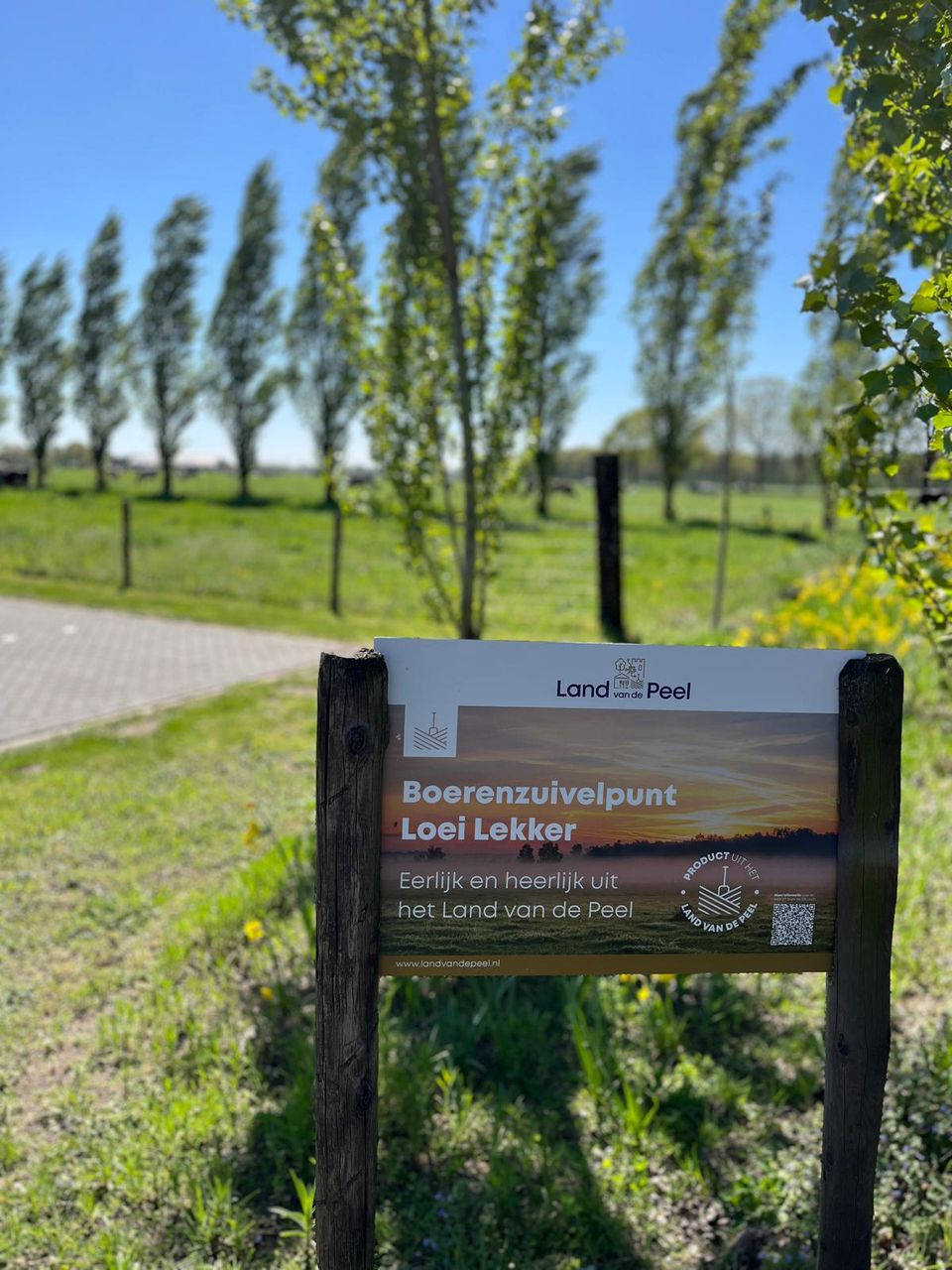 reclamebord met de tekst 'Boerenzuivelpunt Loei Lekker - Eerlijk en heerlijk uit het Land van de Peel'