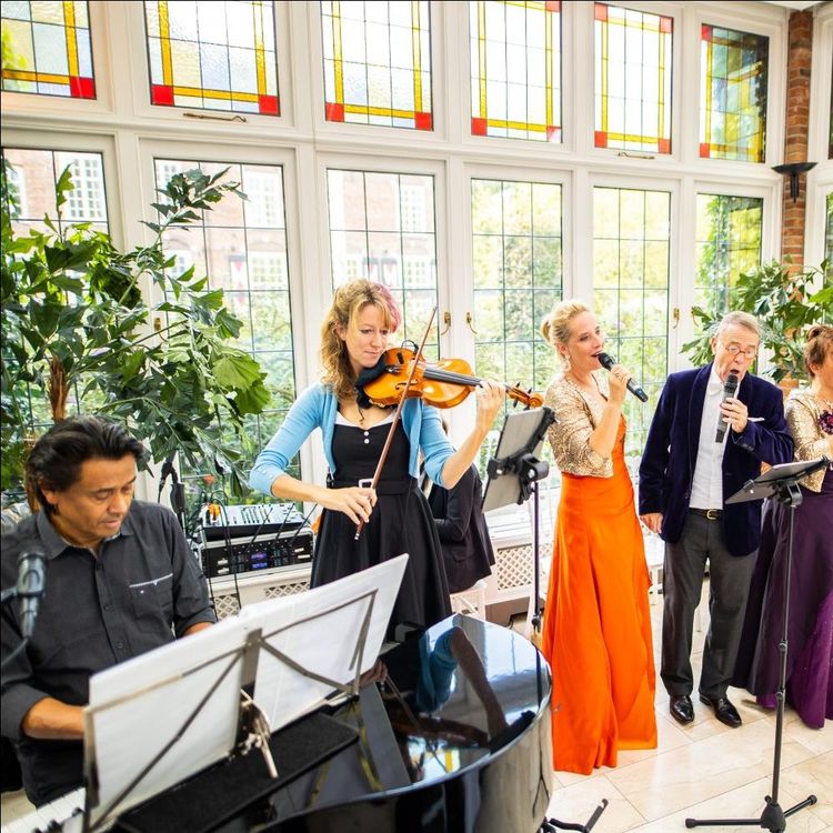 Foto van het muziekensemble met van links naar rechts de pianist, een violiste, een zangeres en een zanger.
