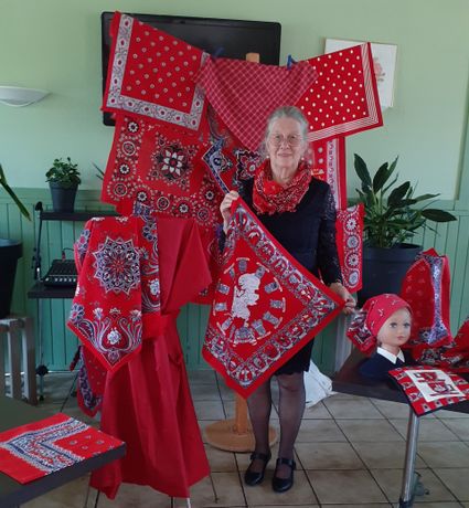 Sara Kalis met een verzameling rode zakdoeken tijdens De verrassende wereld van de zakdoek in Stadsmuseum Woerden.