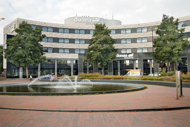 Foto van het gebouw van Dunea met daarvoor een plein met een waterfontein, ook wel Plein Verenigde Naties genoegd