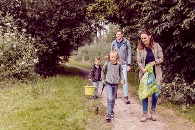 gezin dat zwerfaval opruimt tijdens het wandelen