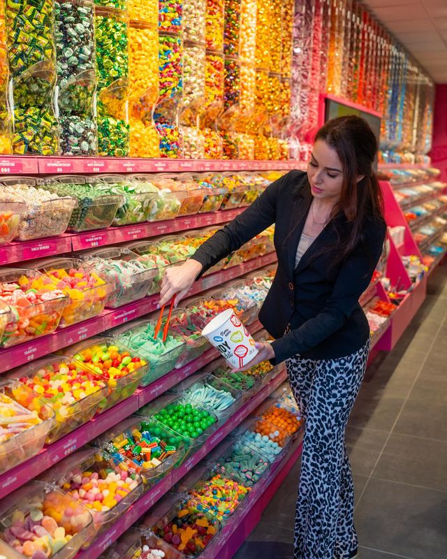 Dame schept snoep in papieren beker