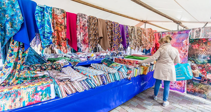 Vrouw zoekt stof uit op de stofmarkt