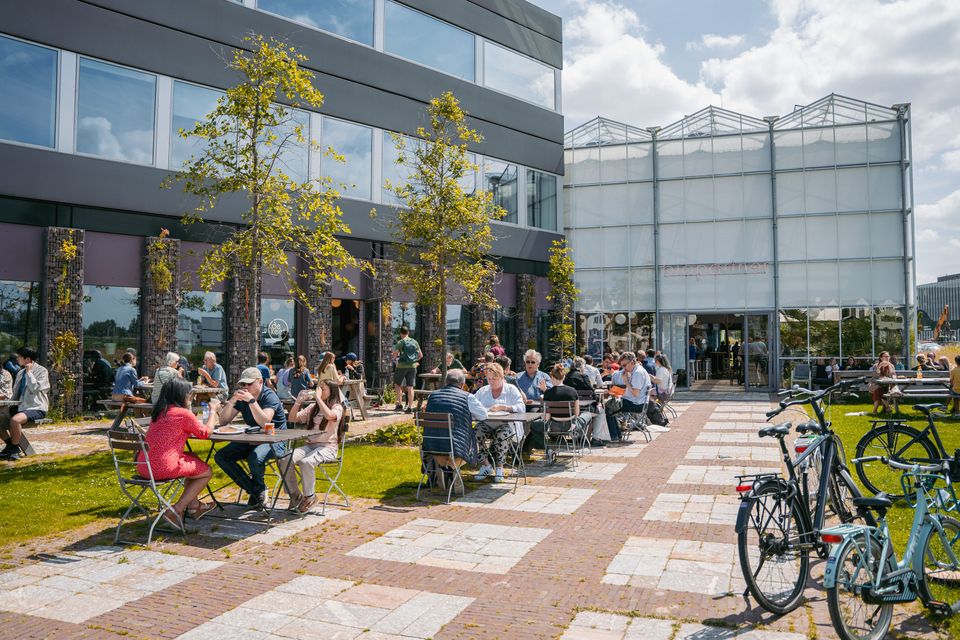 Picnic tables with people in front of one of the BioPartner buildings.