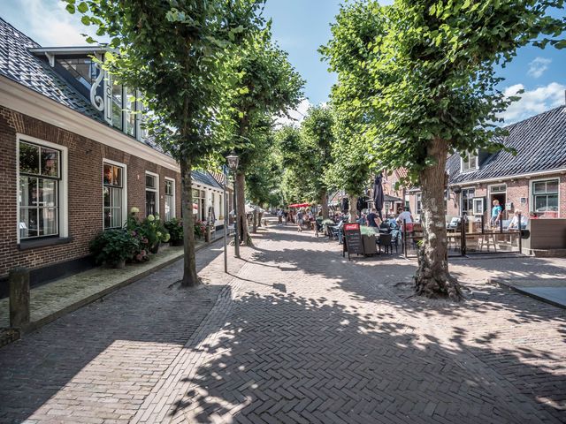 een straat met aan de zijkant terrassen en bomen.