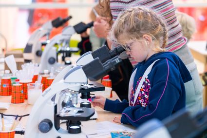 Jongen kijkt door microscoop