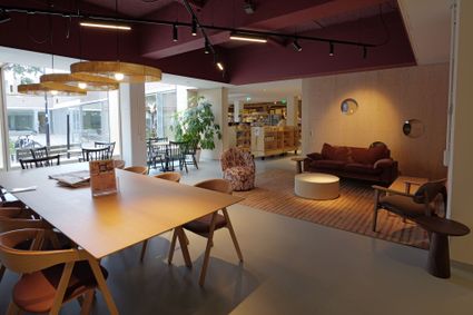 Sfeervol interieur van De Stadskamer in Woerden, met zitplekken, een grote tafel en de bibliotheek op de achtergrond.