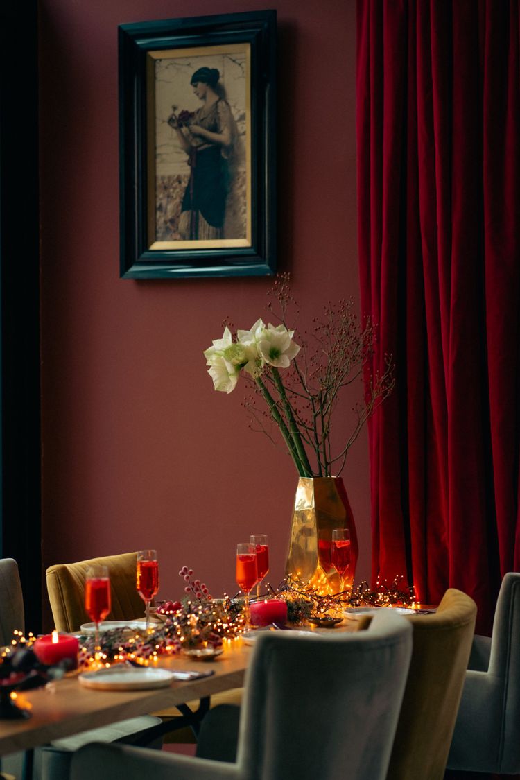 Foto van een sfeervol gedekte eettafel in donkere kleuren.