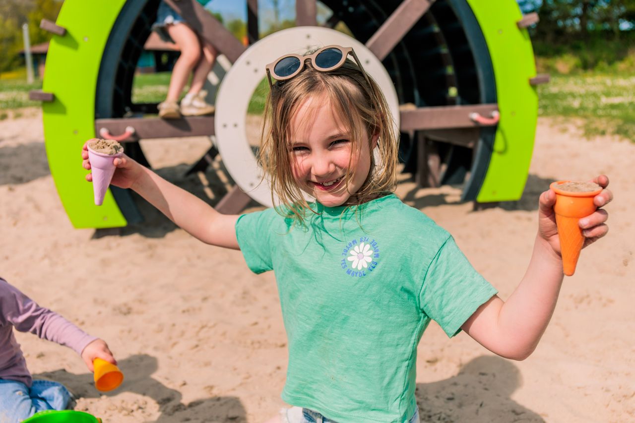 Een meisje speelt in het zand