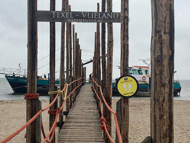 Via een houten brug op het strand bereik je de pont