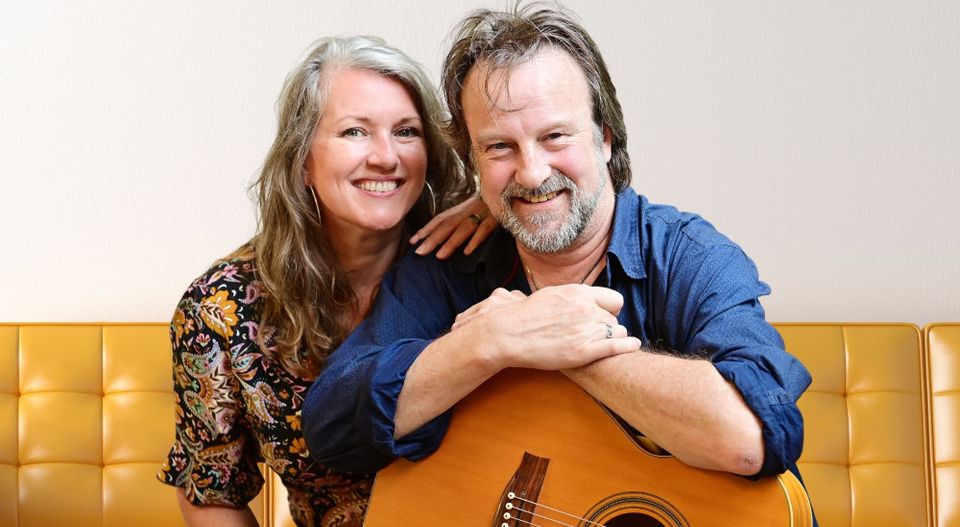 Een vrouw en een man met een gitaar