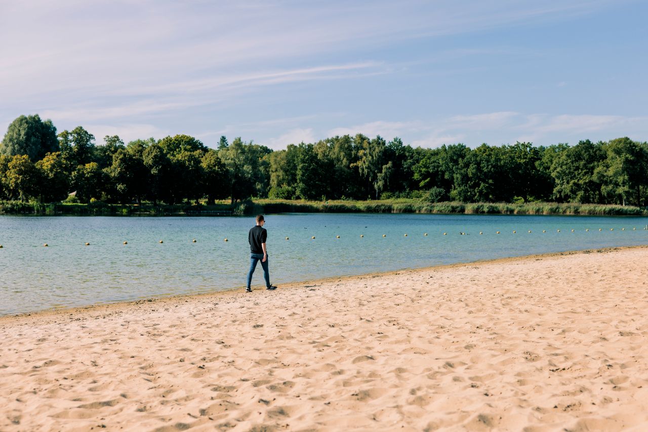 Jongen loopt op het strand.