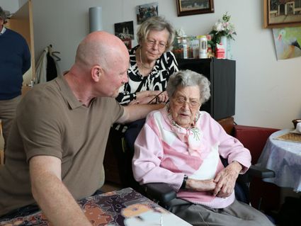 Oudste inwoner van Delft plakt een poppetje op het kunstwerk van Rene Jacobs