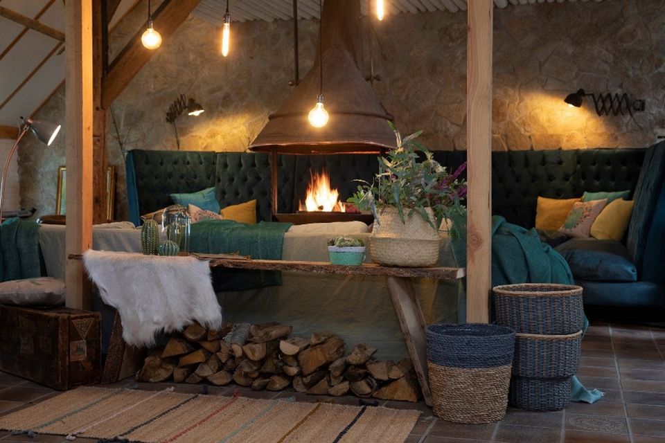 Een knus zitje in een accommodatie met een openhaard in het midden.