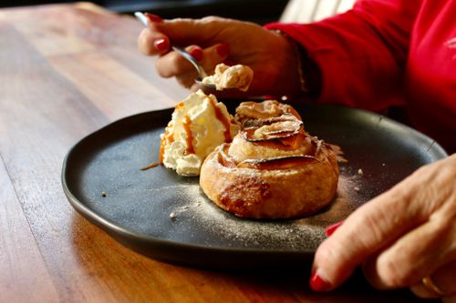 Een tafel met daarop een bord met een gebakje