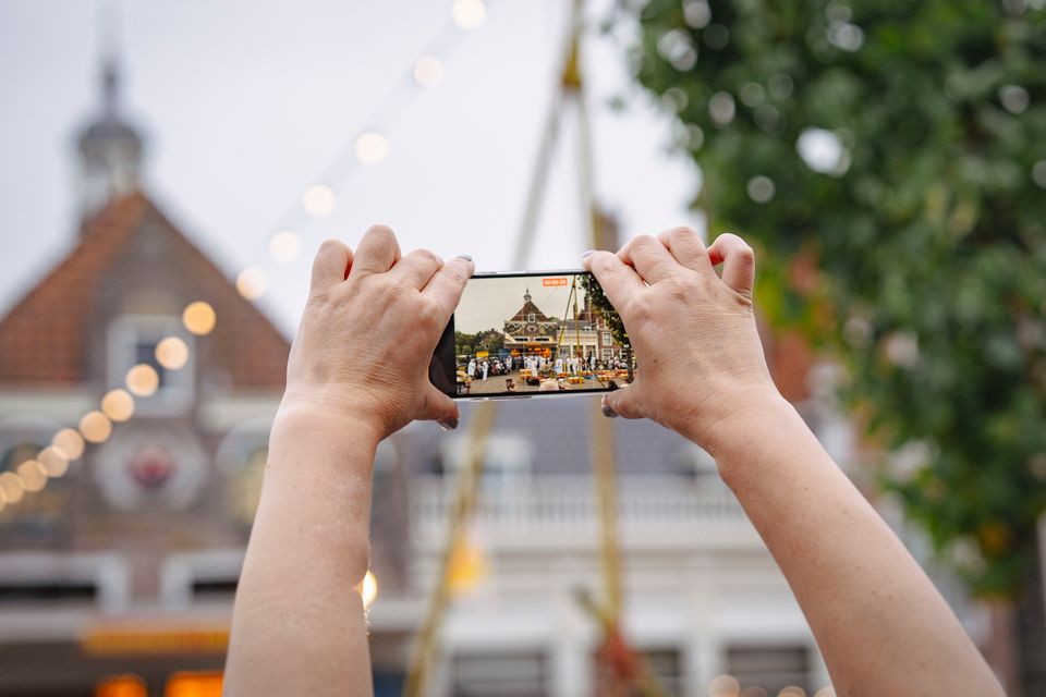 Iemand die een foto maakt tijdens de avondkaasmarkt in Edam