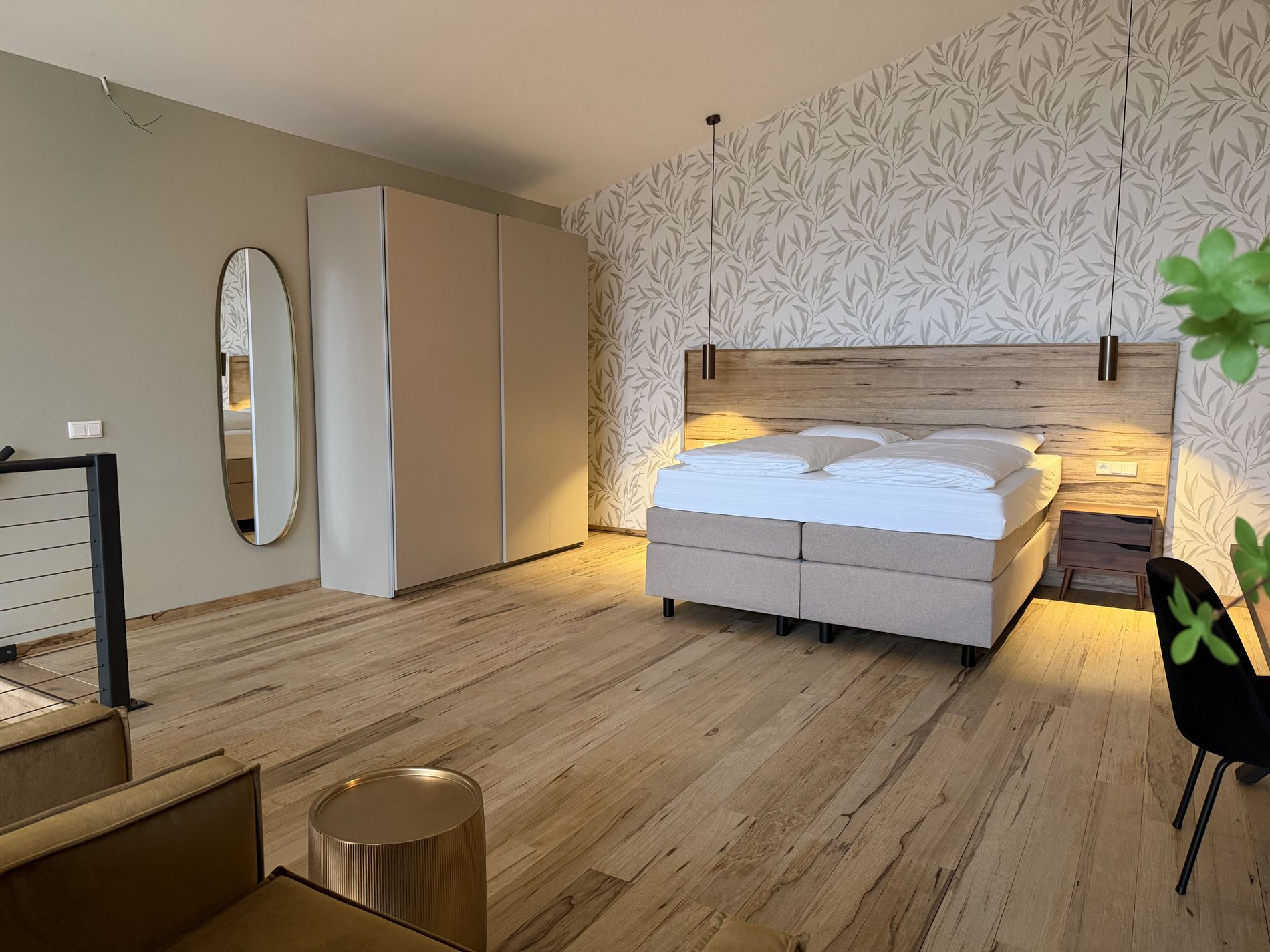 Heel ruime, in beige, wit en met hout ingerichte, slaapkamer van de Luxury Lofts