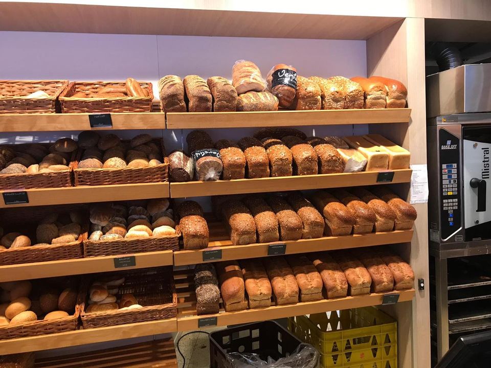 Vers broodassortiment in Bakkerij Versluis in Woerden met verschillende broden in houten schappen.
