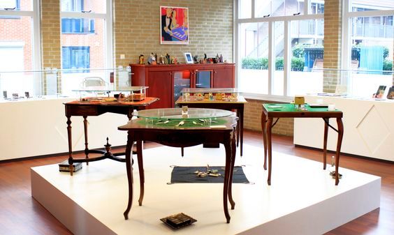 Het Bridgemuseum in Leerdam van binnen, er staan bridgetafels.