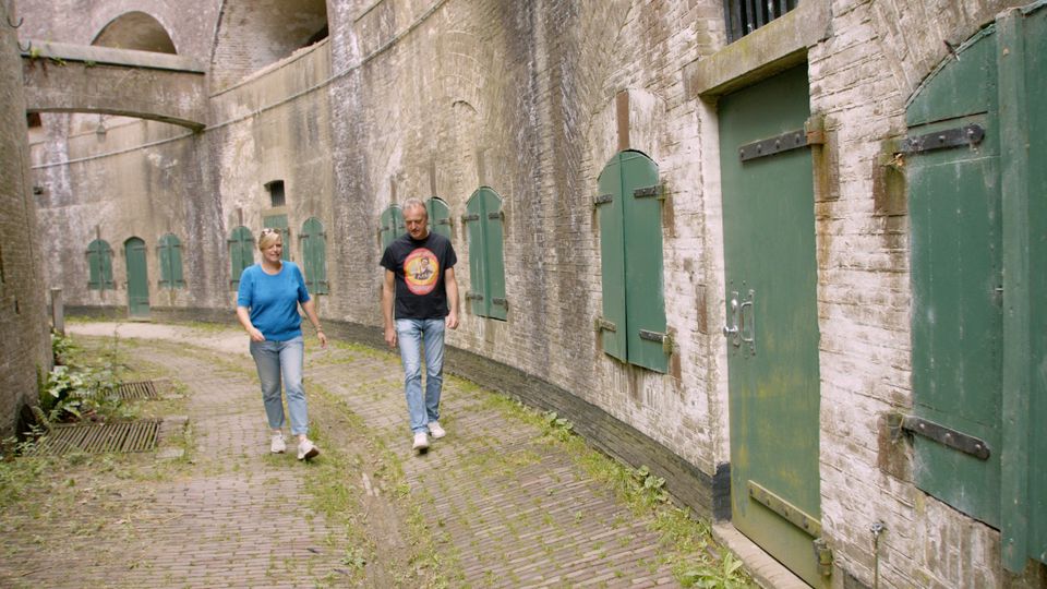 Een man en een vrouw lopen door de rondgang rond een torenfort.