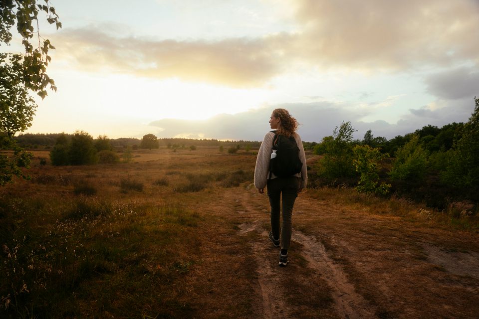 Een vrouw wandelt door de natuur.