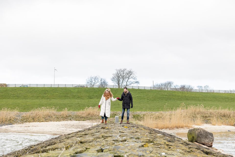 Stelletje wandelt in de winter langs het IJsselmeer.