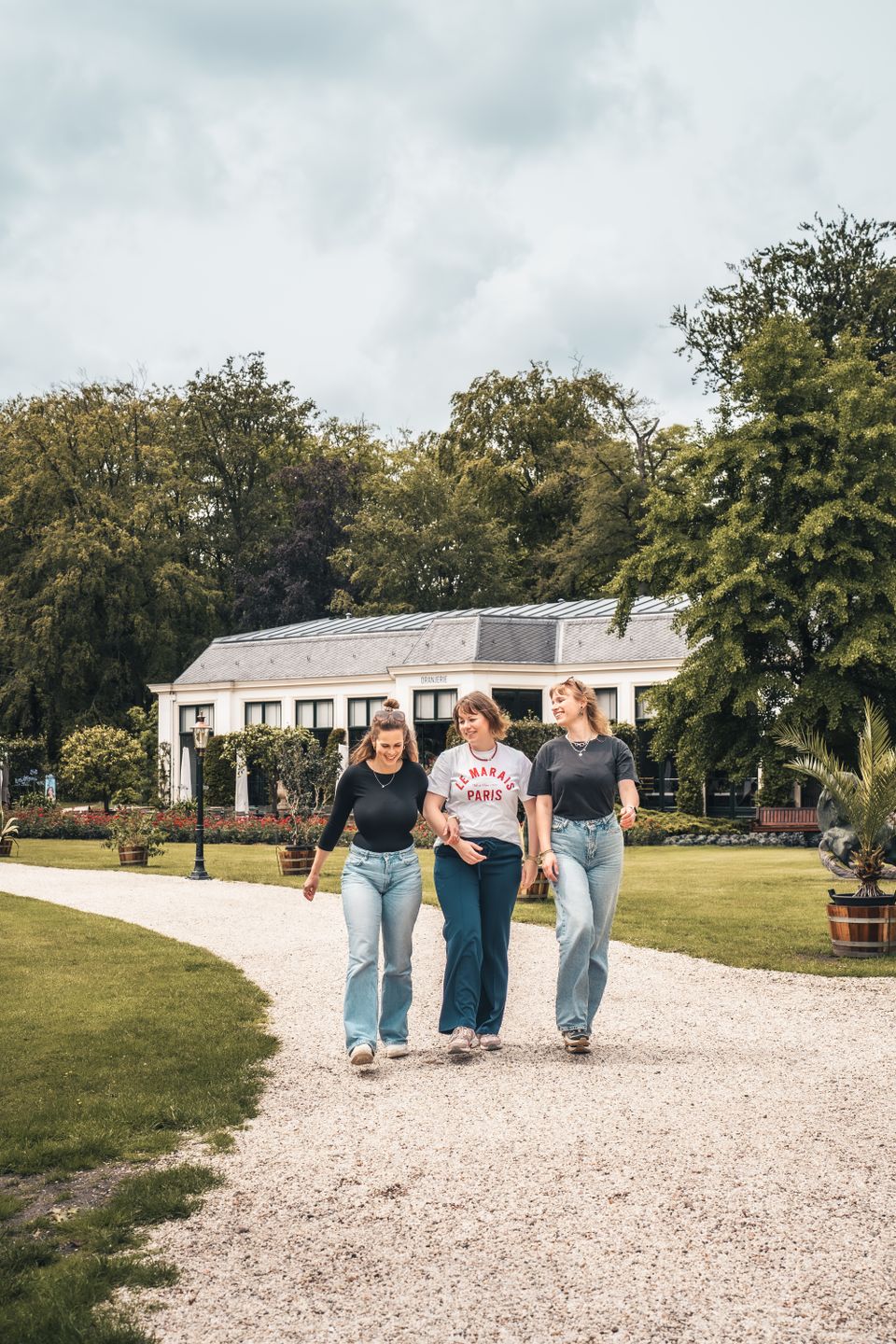 Drie vrienden die wandelen door de tuinen van Paleis Soestdijk