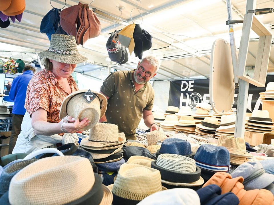 Een koppel bij een kraampje met hoeden op de Markt in Delft