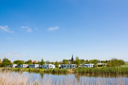 Camping de Finne in Reahus vanaf het water met verschillende campers en caravans.