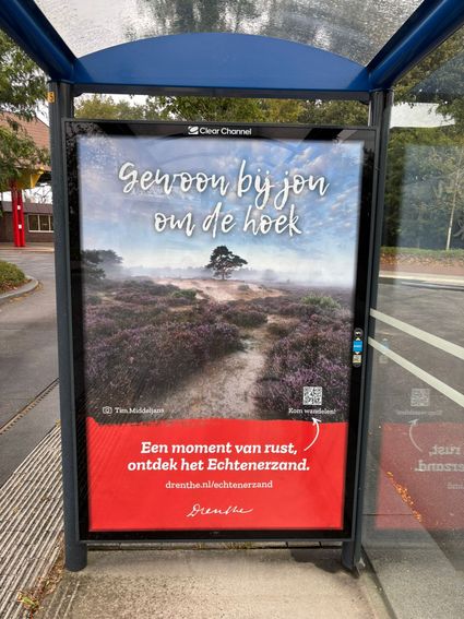 afbeelding van een bushokje poster met een natuurgebied in Drenthe erop.