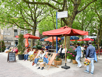 Mensen die heerlijk aan het vertoeven zijn op het doelenplein in delft