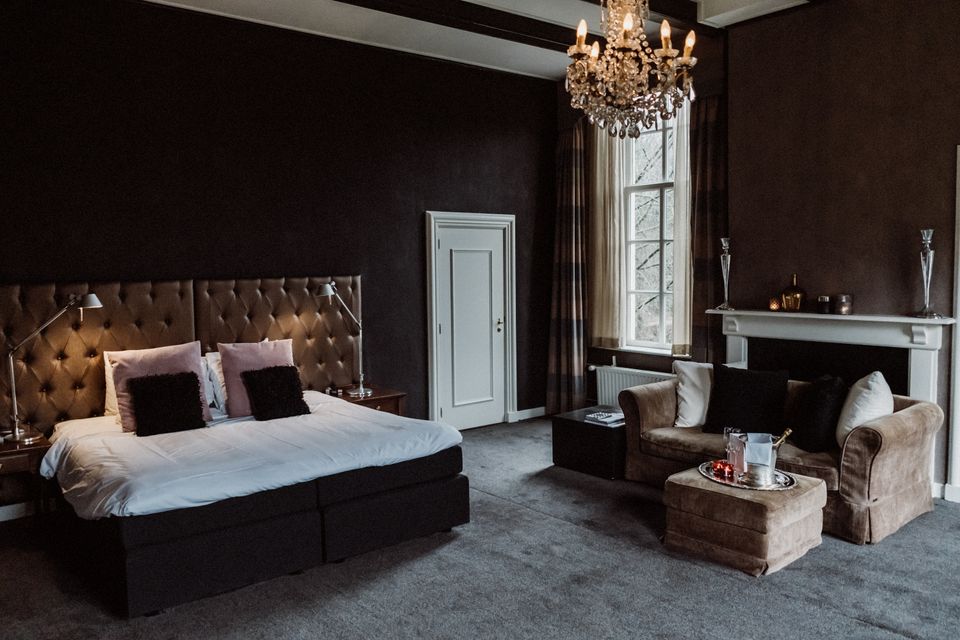 Hotelkamer met tweepersoonsbed en een kroonluchter.