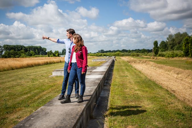 Een man en een vrouw staan op de betonnen rand van Fectio en kijken over het fort.