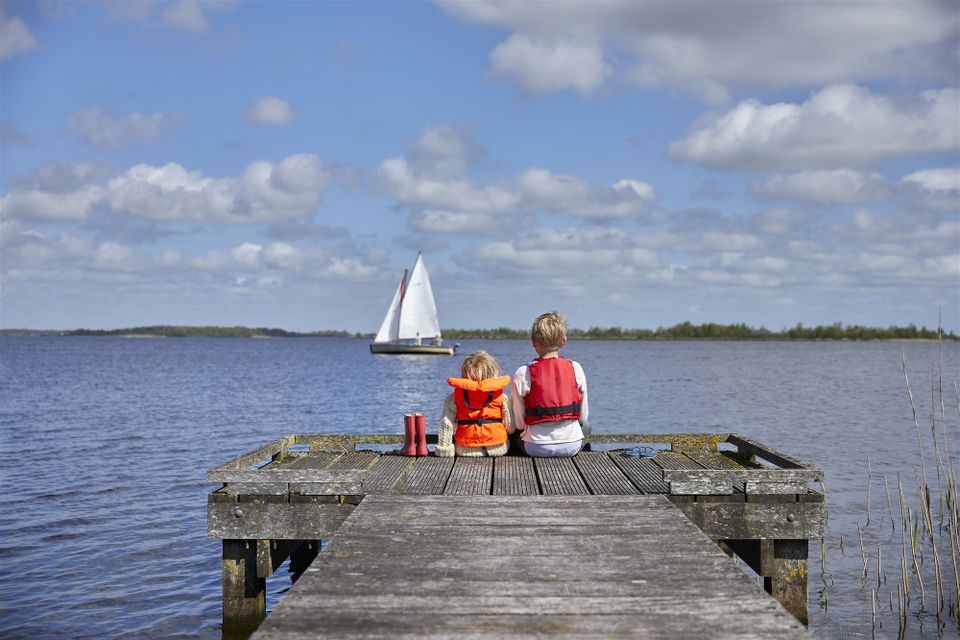 Friese meren, twee kindjes zitten op een steiger en kijken uit op het water.