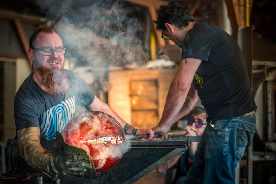 De glasblazers werken samen in de Glasblazerij van het Nationaal Glasmuseum