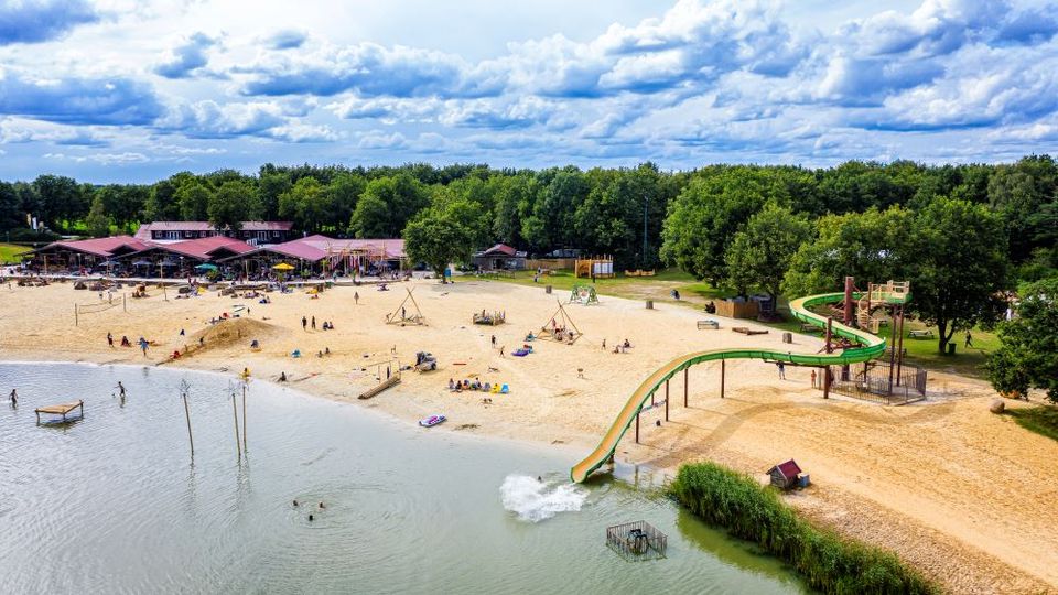 Ein Drohnenaufnahme vom Ermerstrand mit Rutsche, Pavillon, Strand und See.