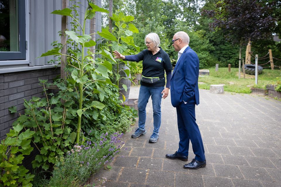 Wethouder John van Engelen kijkt samen met een vrijwilliger van Bouwgein naar de geveltuinen