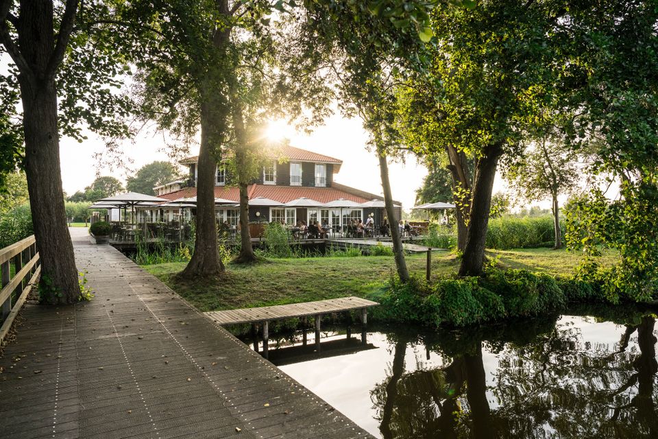 Gezellig terras van Restaurant Kameryck aan het water, omringd door groen in het Groene Hart.