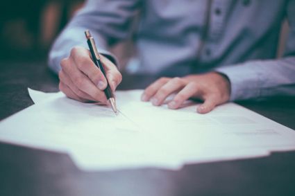 People writing on document.