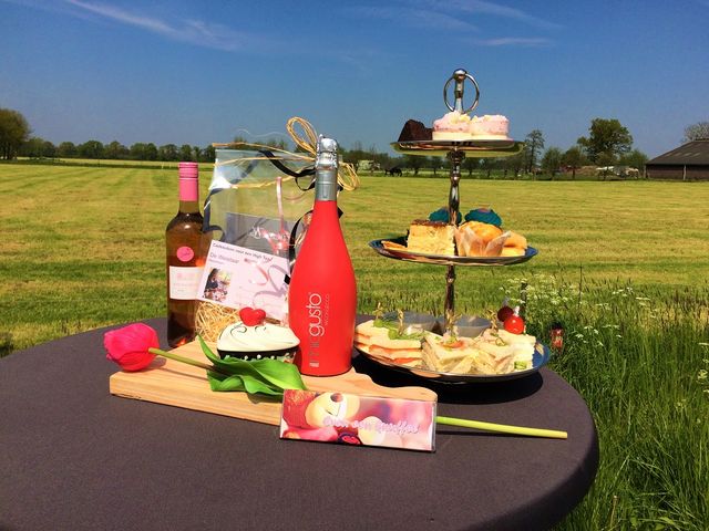 High tea met hapjes en drankjes bij Boerderij De Weistaar in Maarsbergen, met uitzicht over het landelijke buitengebied. De foto benadrukt streekproducten, gastvrijheid en genieten op de boerderij.