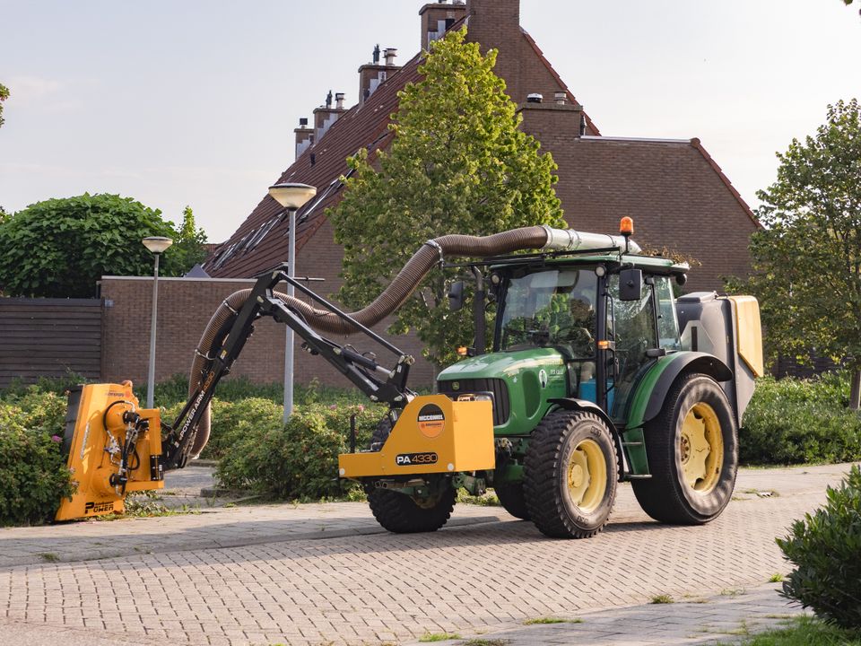 Een tractor rijdt in een woonwijk