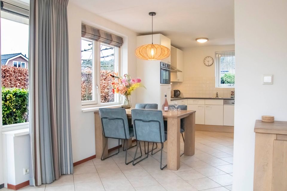 De gezellige woonkamer van de luxe bungalow met grote eettafel en goed uitgeruste keuken