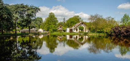 Sfeervol uitzicht op Landgoed Bredius in Woerden met vijver, bomen en historische gebouwen, locatie van het mini-festival met muziek en kunst