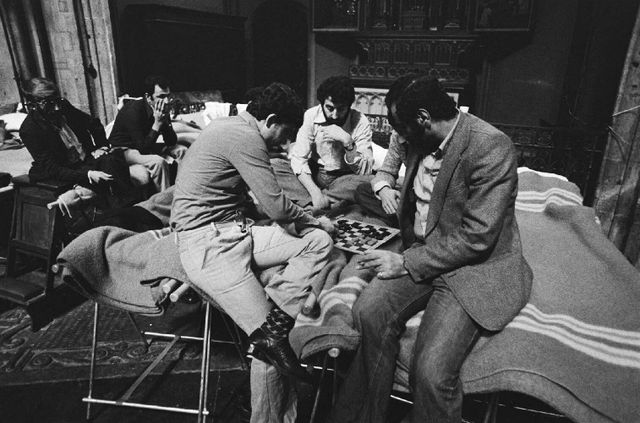 Een groepje mannen speelt een potje dammen. 