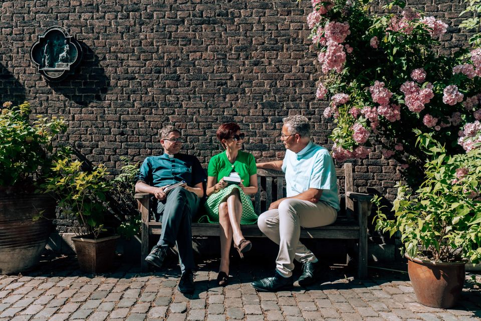 Chazia Mourali on bench courtyard Sint Servaasbasiliek Maastricht with two other people