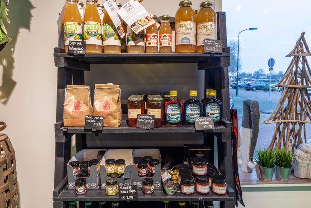 Een artikel rek met verschillende streek producten zoals sap, dipjes, meel en honing