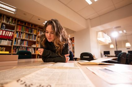 vrouw aan tafel met oude documenten