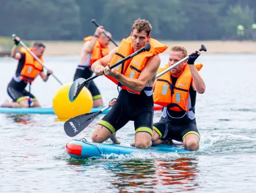 Mannen zitten op een SUP en doen mee aan de Nunspeetse Keiler.