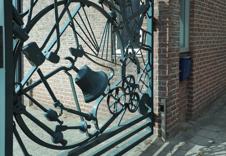 hekwerk met klokken tandwielen en ander smeedwerk