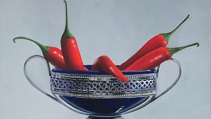 Stilleven van een zilveren schaal met een blauw-paarse binnenkant waarin rode pepers uitsteken.